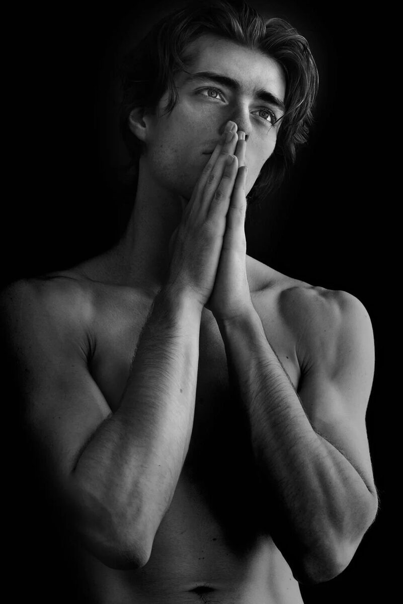 Fine-art black and white portrait of a man, hands pressed to his face