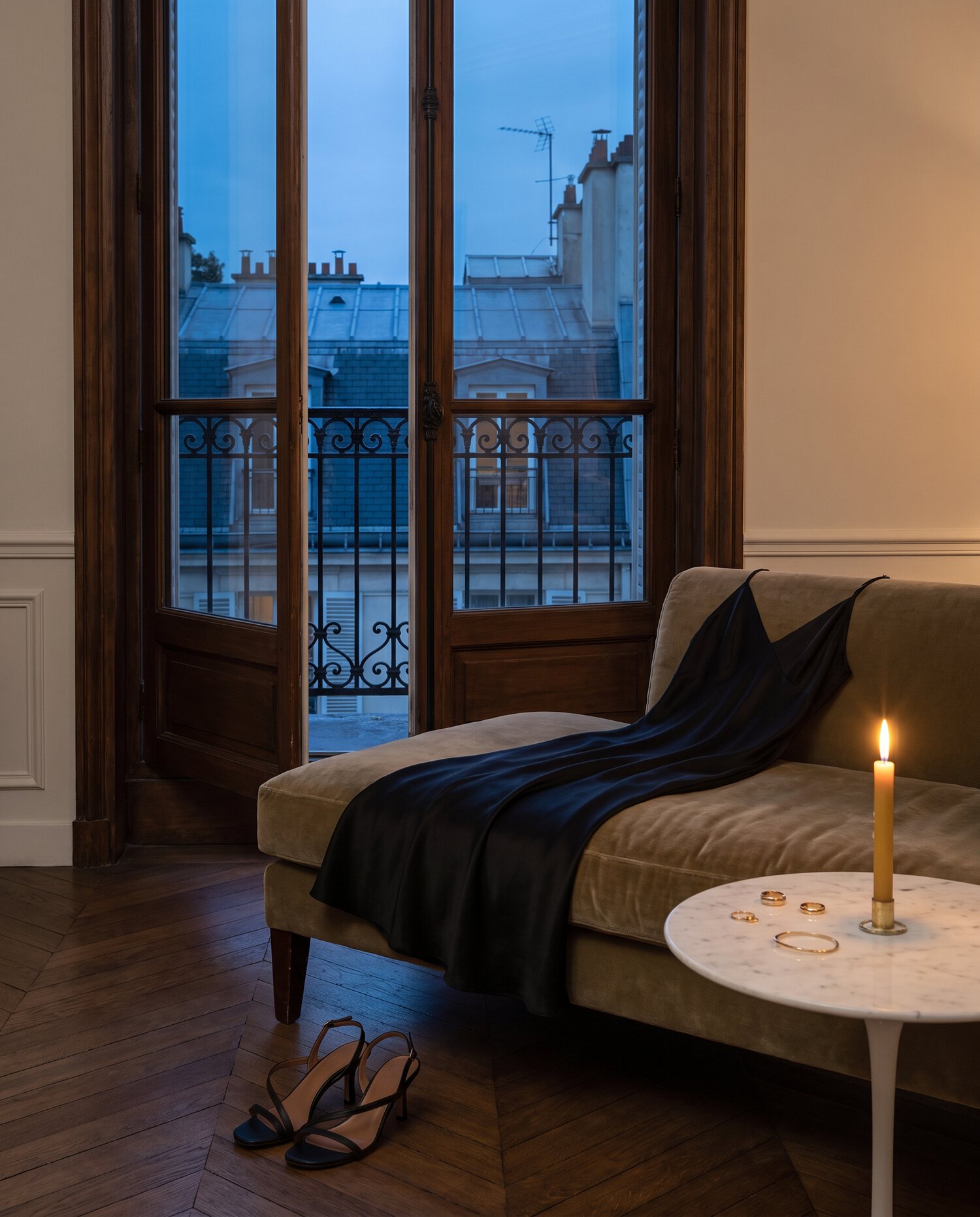 Black silk slip gown on a chaise, Paris balcony at blue hour